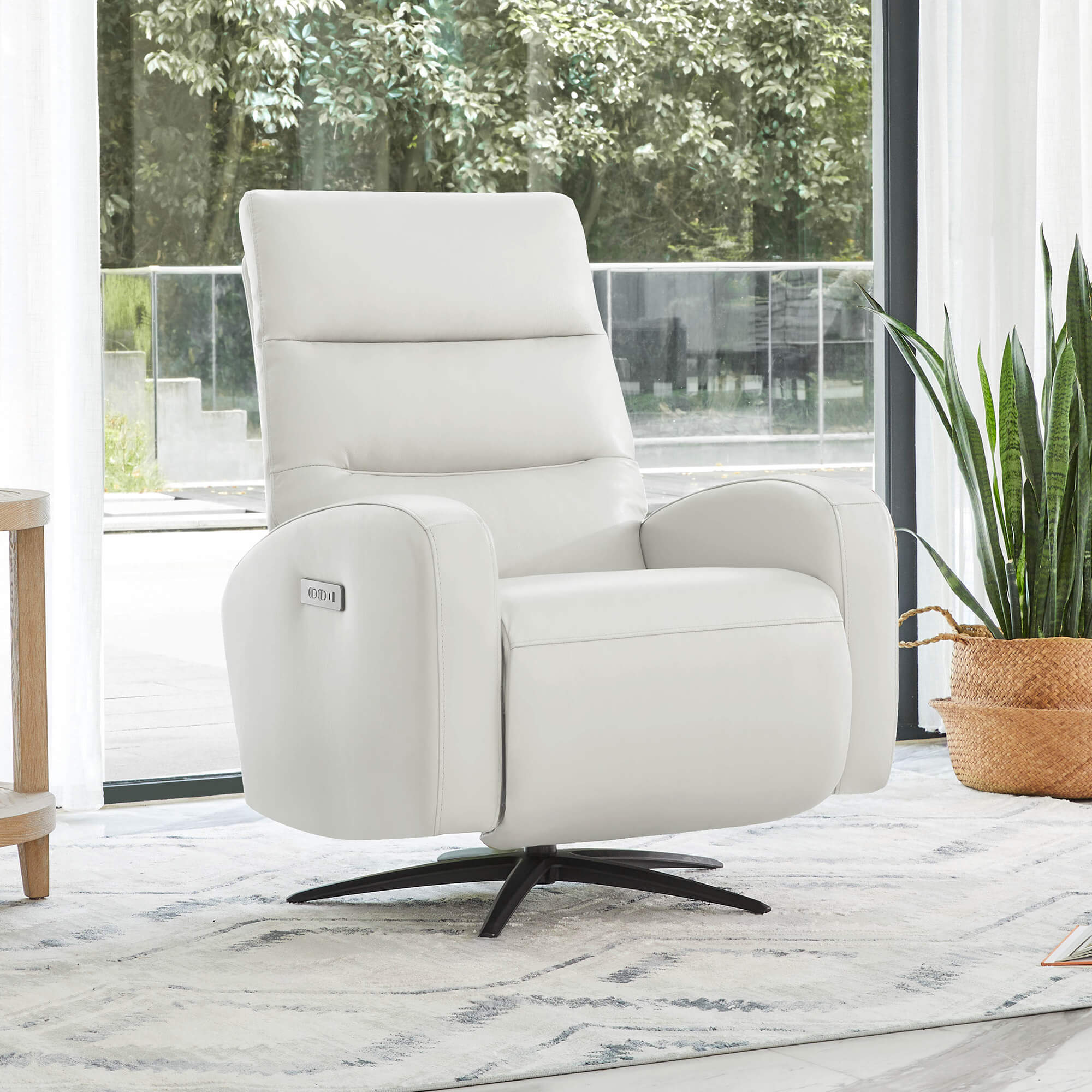 A white leather power swivel recliner chair in a modern living room.
