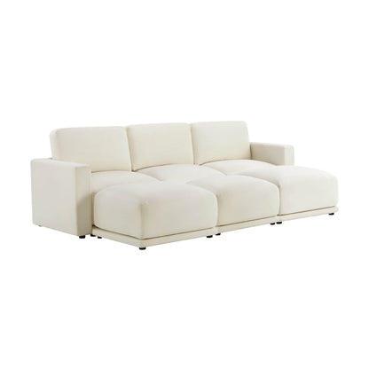 Angled view of a modern white sectional sofa with three seats and low armrests, showcasing its plush cushions and minimalist design.