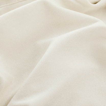 A close-up of a beige fabric with a small blue dot, highlighting the texture and folds.