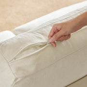Hand unzipping cushion cover on durable chaise sectional sofa.