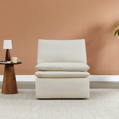 Cream armless chair with plush, reversible cushions in modern living room setting.