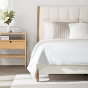 Serene upholstered platform bed with light headboard and wooden legs in bright bedroom - CHITA Living