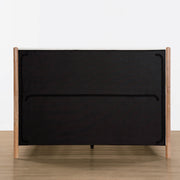 Back view of Serene upholstered platform bed with wooden legs and black fabric - CHITA Living