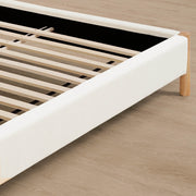Close-up of upholstered platform bed with wooden frame and slats, showcasing quality craftsmanship - CHITA Living