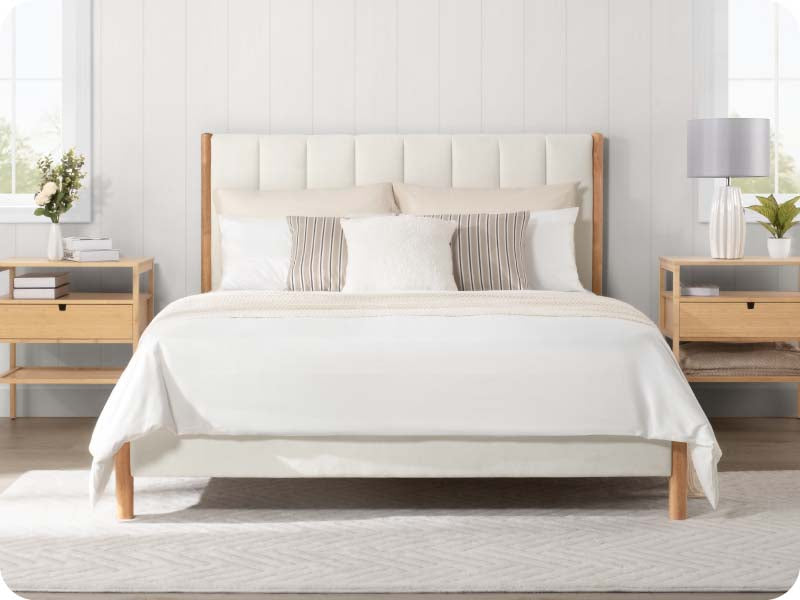Modern queen-size bed with light bedding and natural wood nightstands in airy bedroom decor - CHITA Living