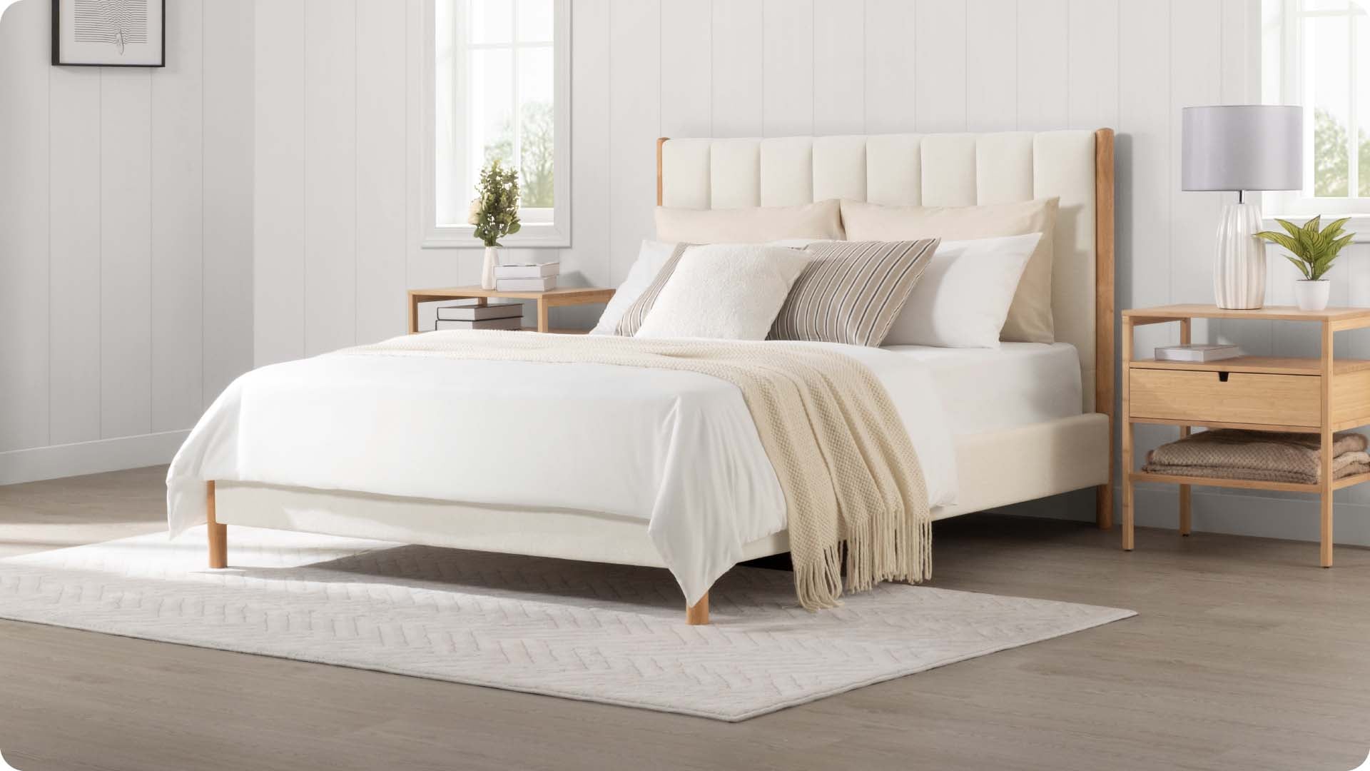 Modern queen-size bed with neutral bedding and wooden nightstands in bright bedroom - CHITA Living