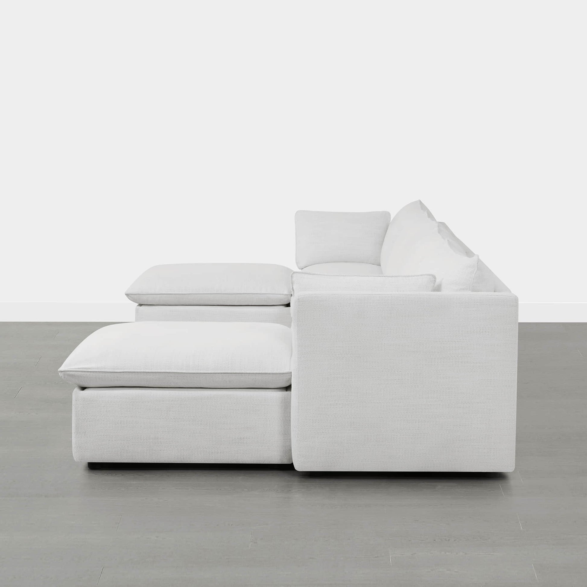 Side view of modern white modular sofa with chaise and plush cushions in minimalistic room - CHITA Living