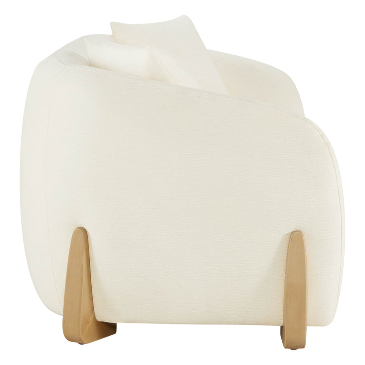 Side view of a modern sofa with curved design, cream upholstery, and wooden legs