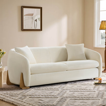 Elegant cream modern sofa with wood accents in a cozy living room.