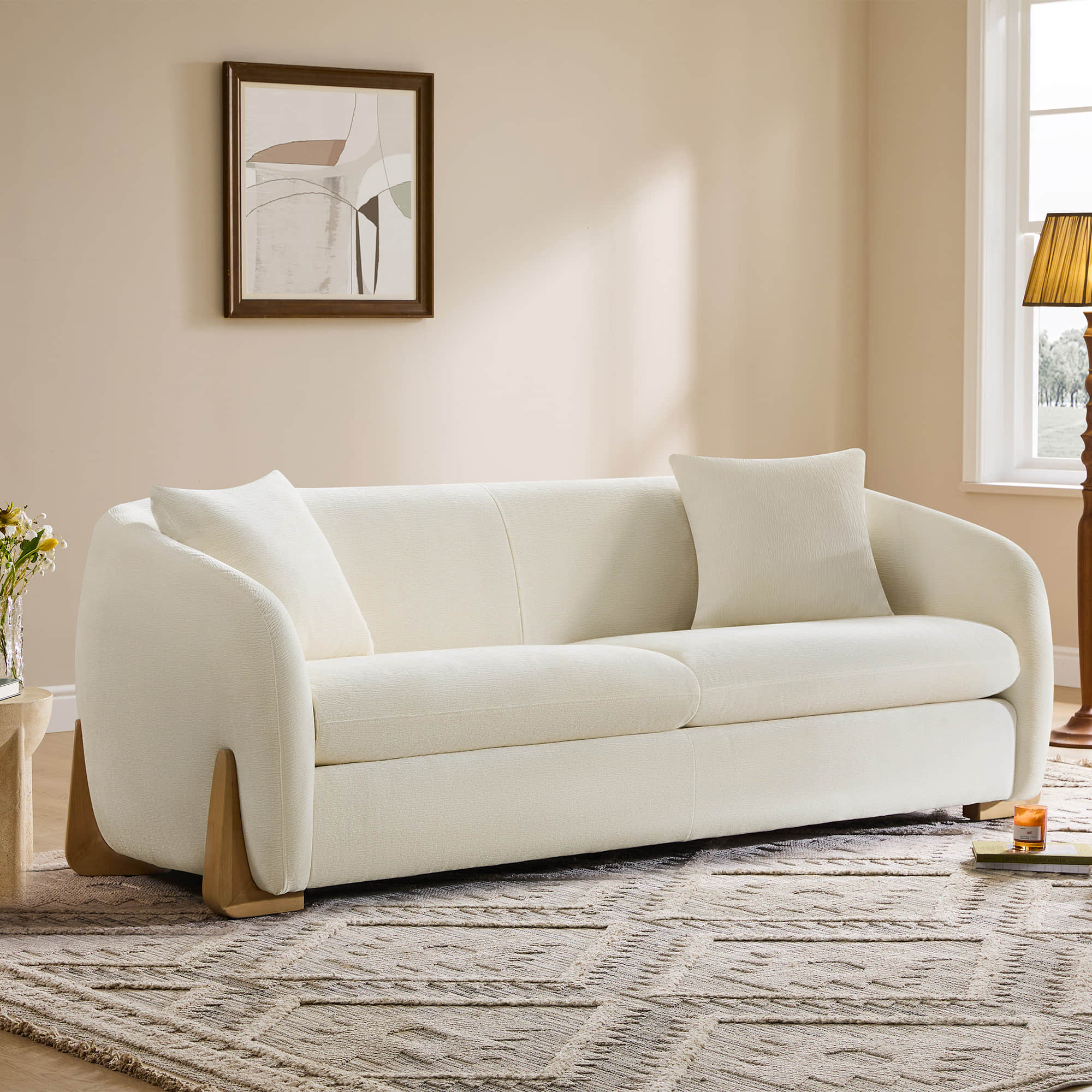 Elegant cream modern sofa with wood accents in a cozy living room.