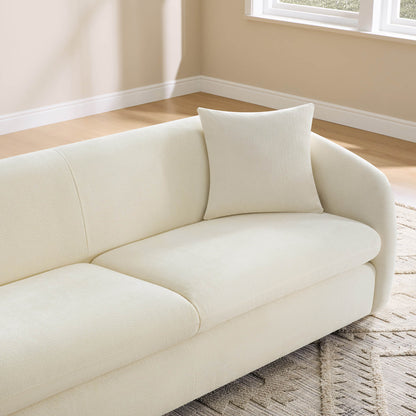 A close-up of a cream modern sofa with a matching pillow, highlighting its elegant design and soft texture.