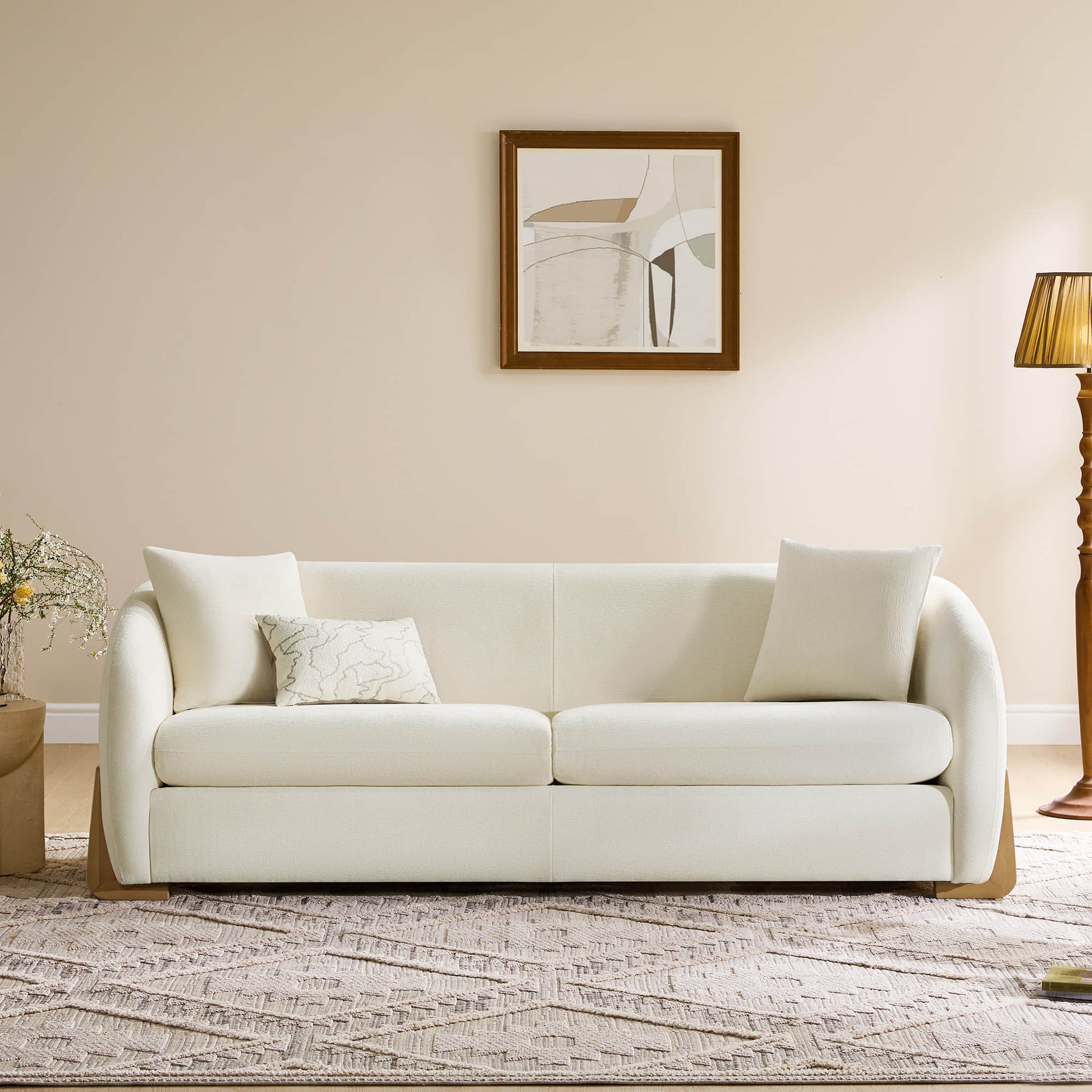 Cream modern sofa with wooden accents, elegantly placed in a cozy living room setting.
