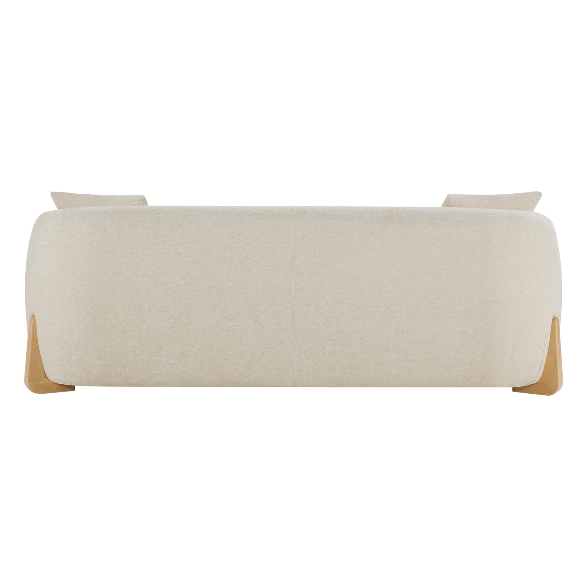Rear view of a modern cream sofa with a smooth, rounded design and wooden legs, showing two cushions peeking over the backrest.