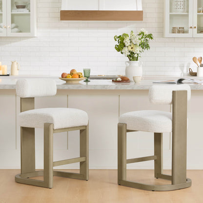 Troy Boucle Counter Stools with solid wood frames and cream bouclé upholstery add a modern touch to the kitchen.