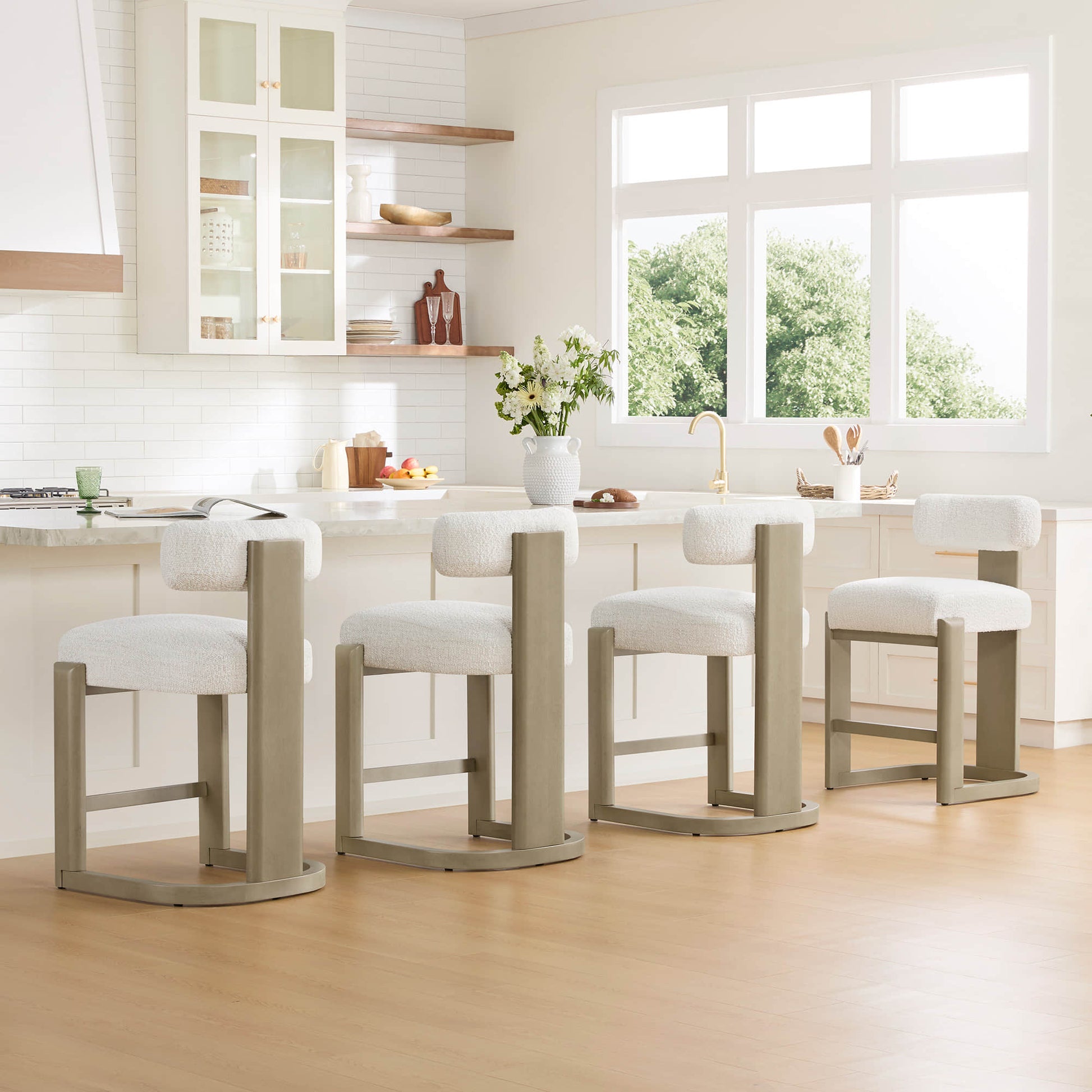 Troy Boucle Counter Stools with solid wood frames and cream bouclé upholstery add a modern touch to the bright kitchen.