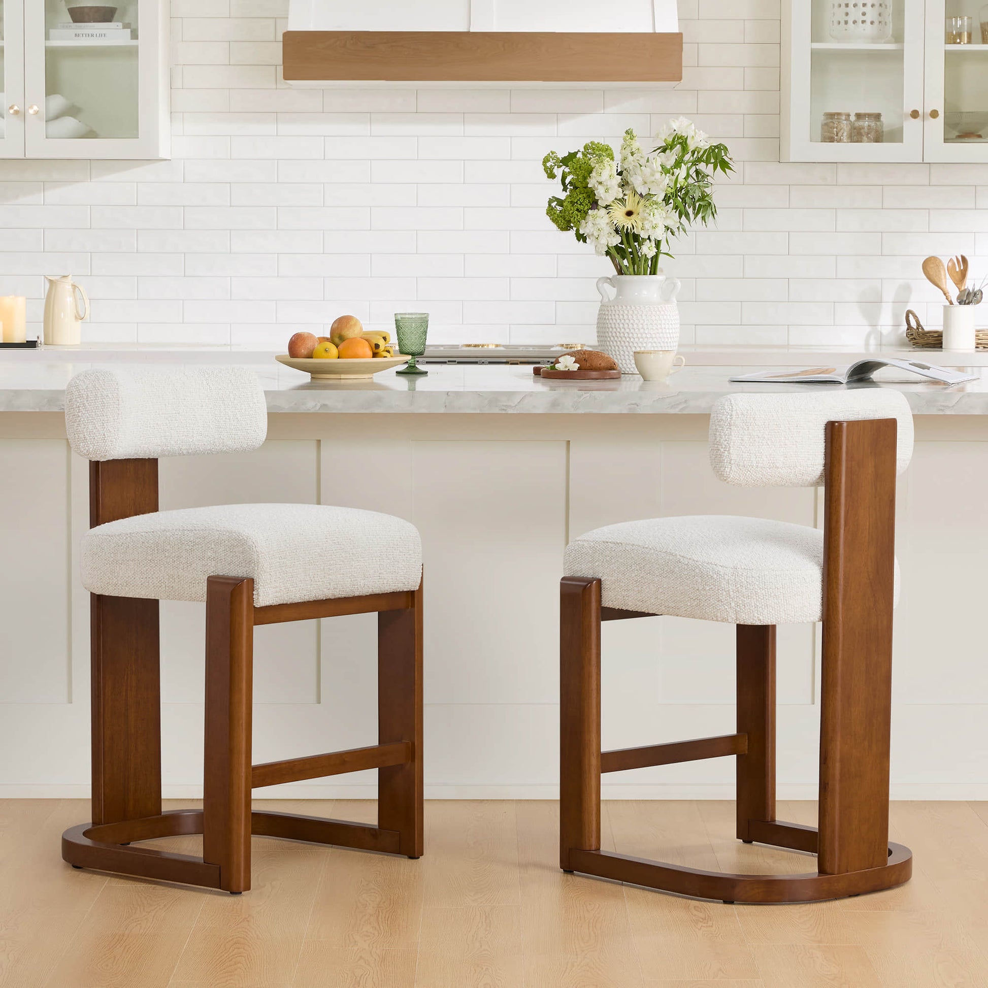 Troy Boucle Counter Stools with solid wood frames and cream bouclé upholstery complement the modern kitchen's aesthetic.