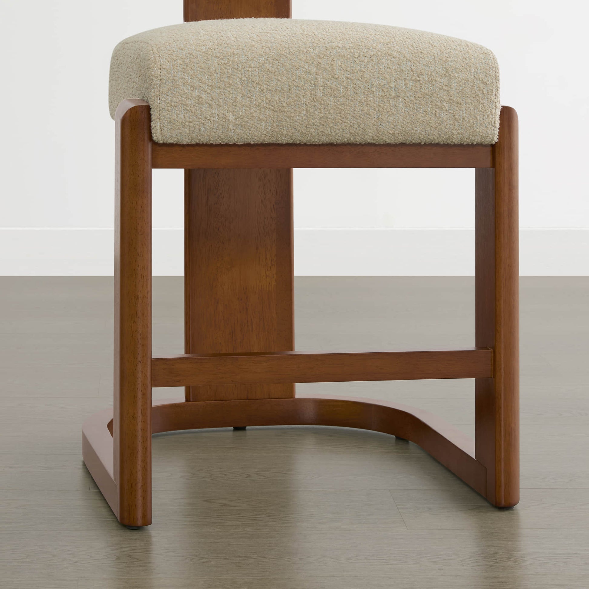 Troy Boucle Counter Stools with solid wood frames and beige bouclé upholstery offer a sleek, modern design.