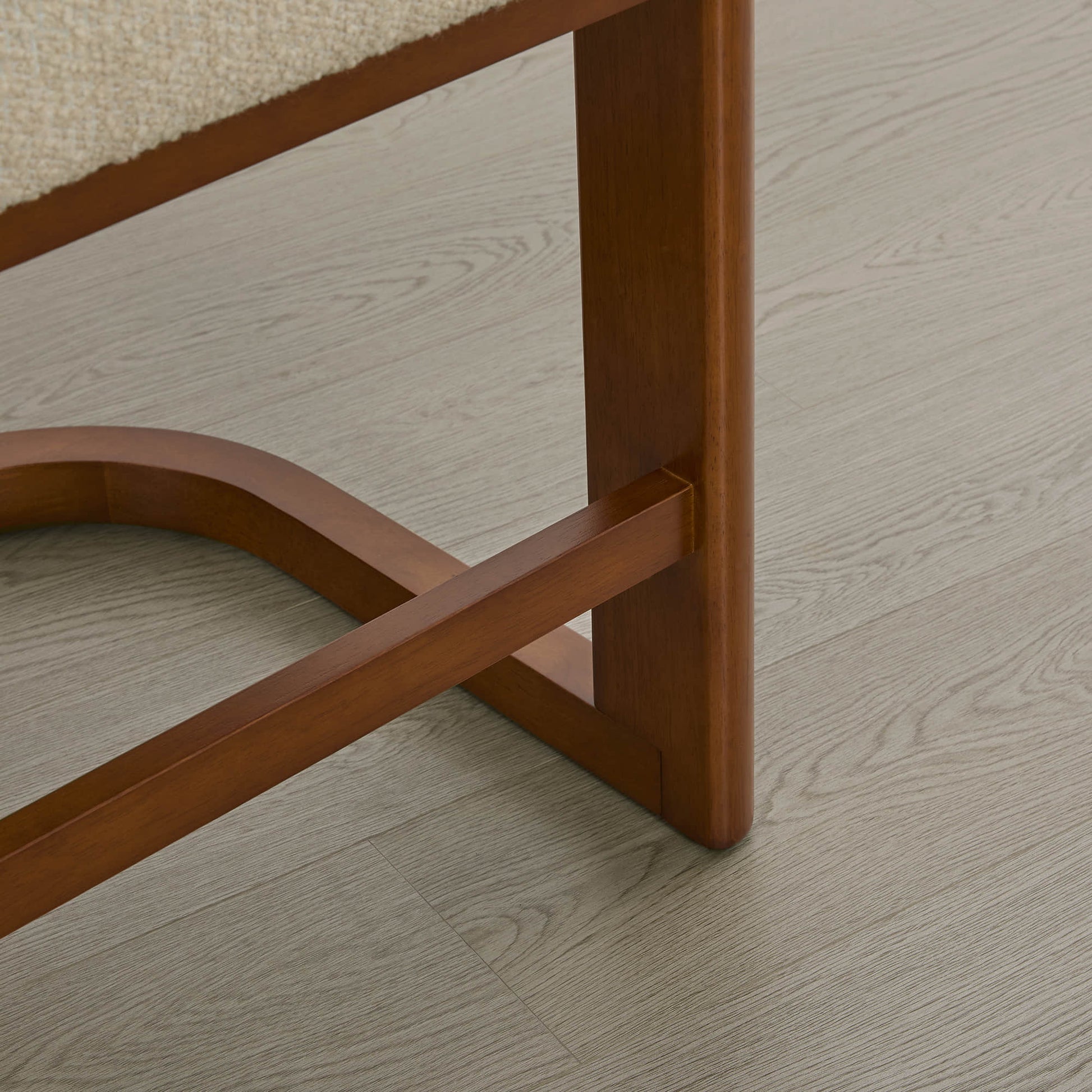 Troy Boucle Counter Stools feature solid wood legs with a curved base, showcasing elegant craftsmanship.