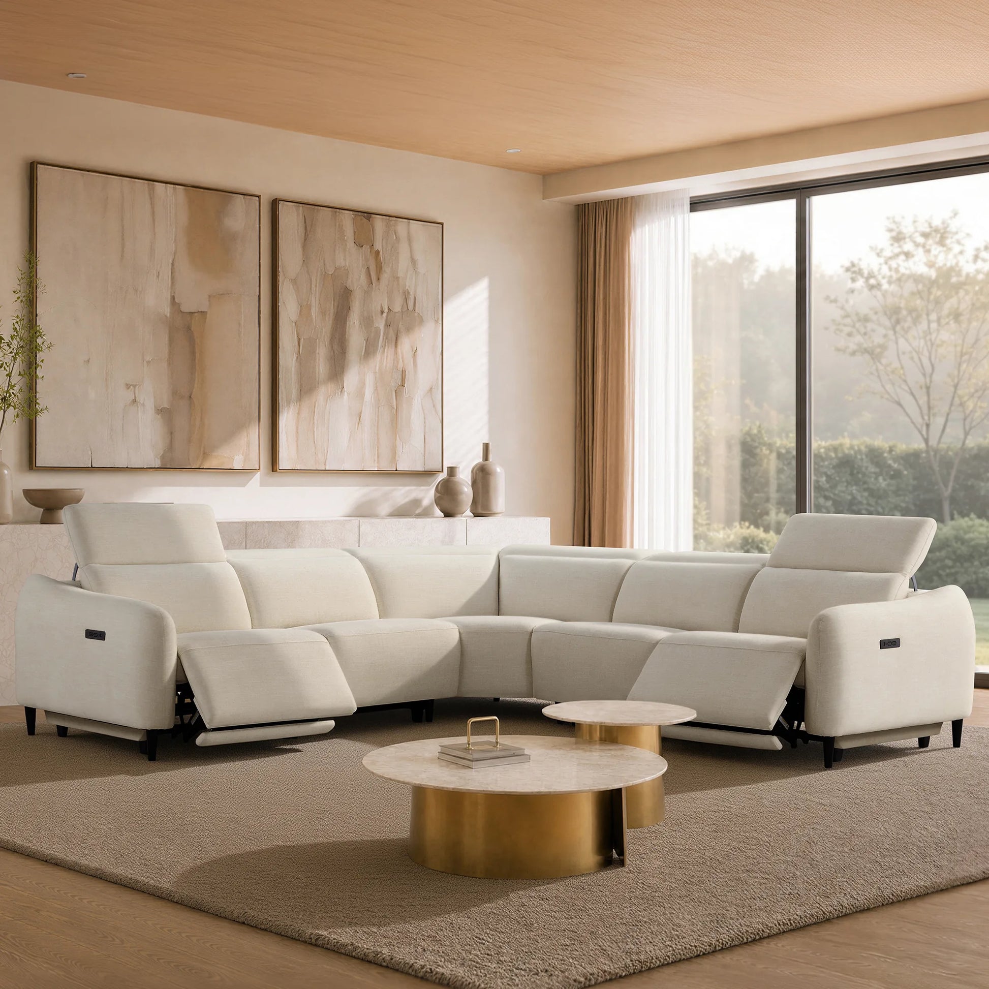 A modern white sectional sofa with reclining seats, styled in a bright, contemporary living room with gold coffee tables, a beige rug, and large abstract wall art.