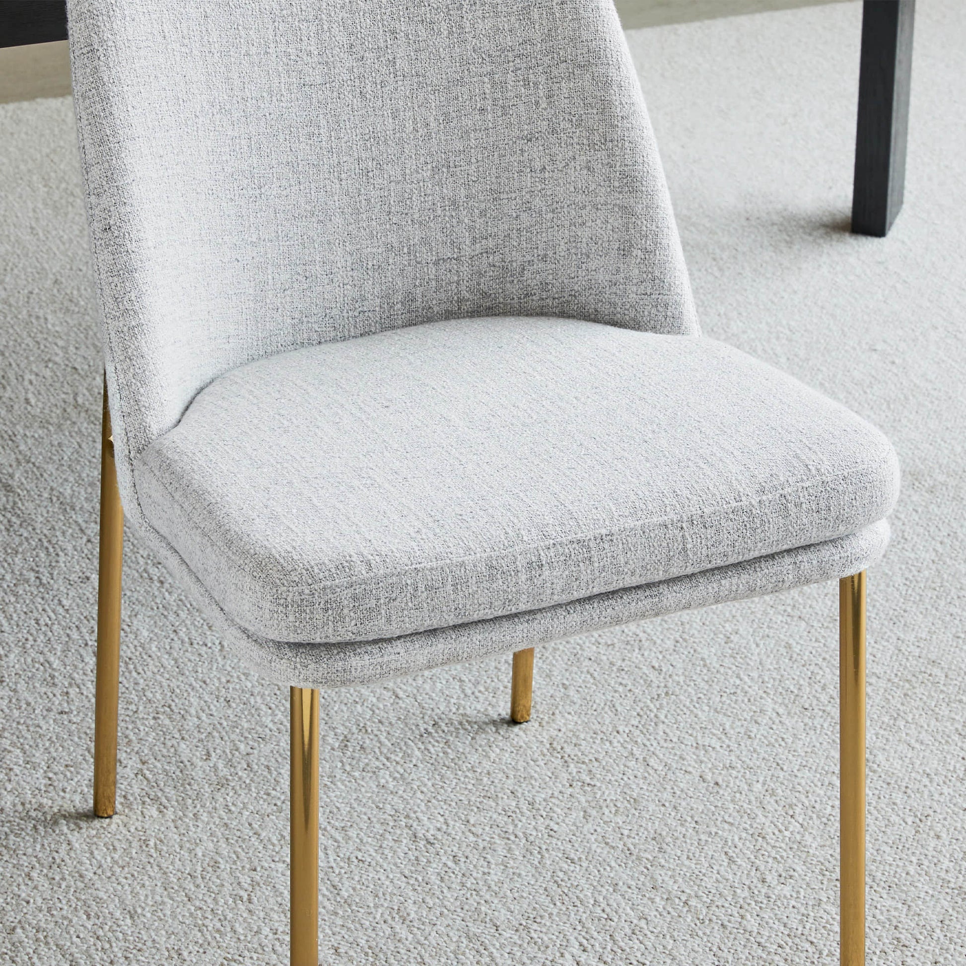 Golda Dining Chair, light gray fabric with gold legs, close-up of seat and backrest.