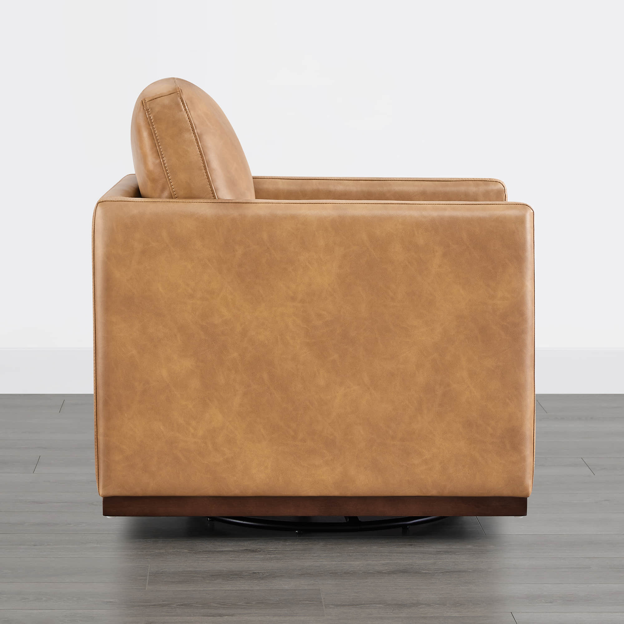 Tan leather Henry Modern Swivel Accent Chair back view showcasing wooden base - CHITA Living