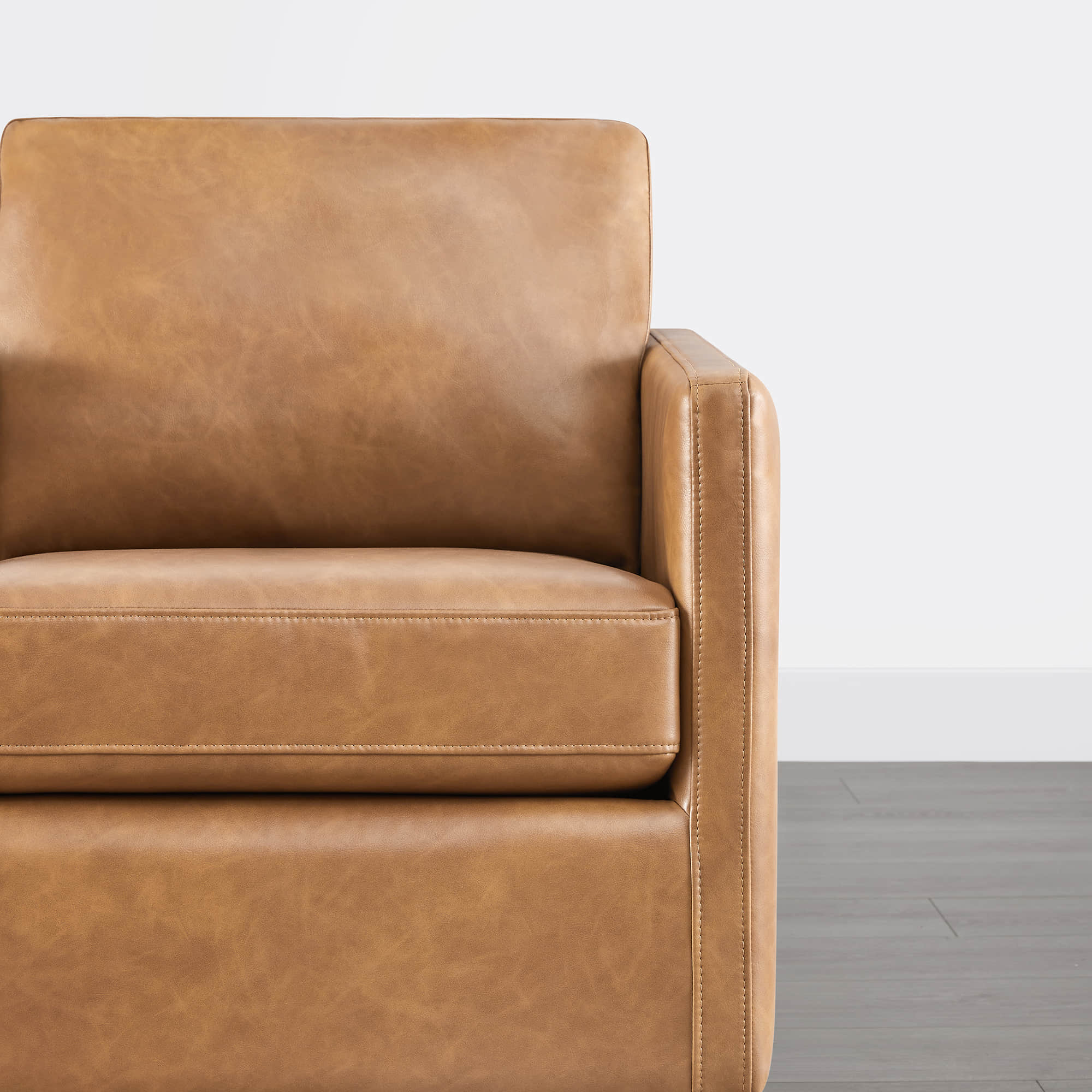 Tan leather cushion detail of Henry Modern Swivel Accent Chair's armrest and seat - CHITA Living