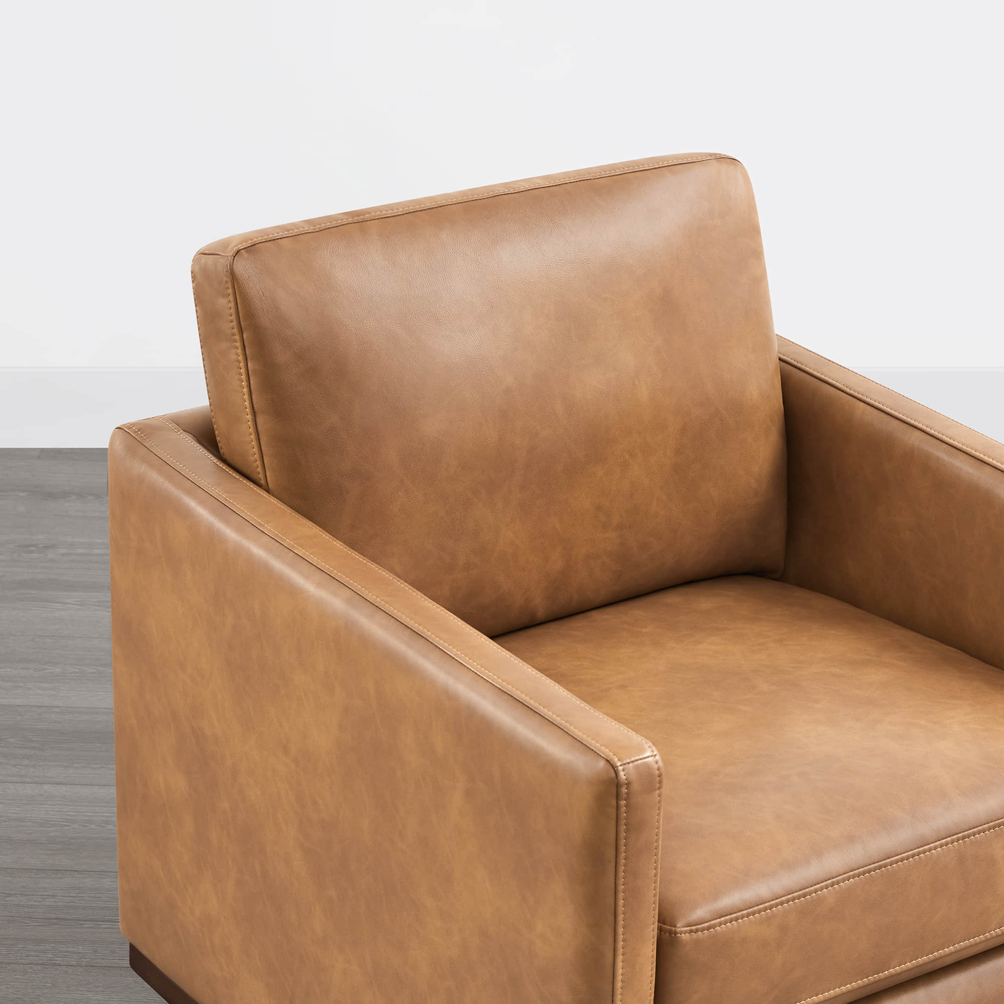 Detail of tan leather cushion and armrest on Henry Modern Swivel Accent Chair - CHITA Living