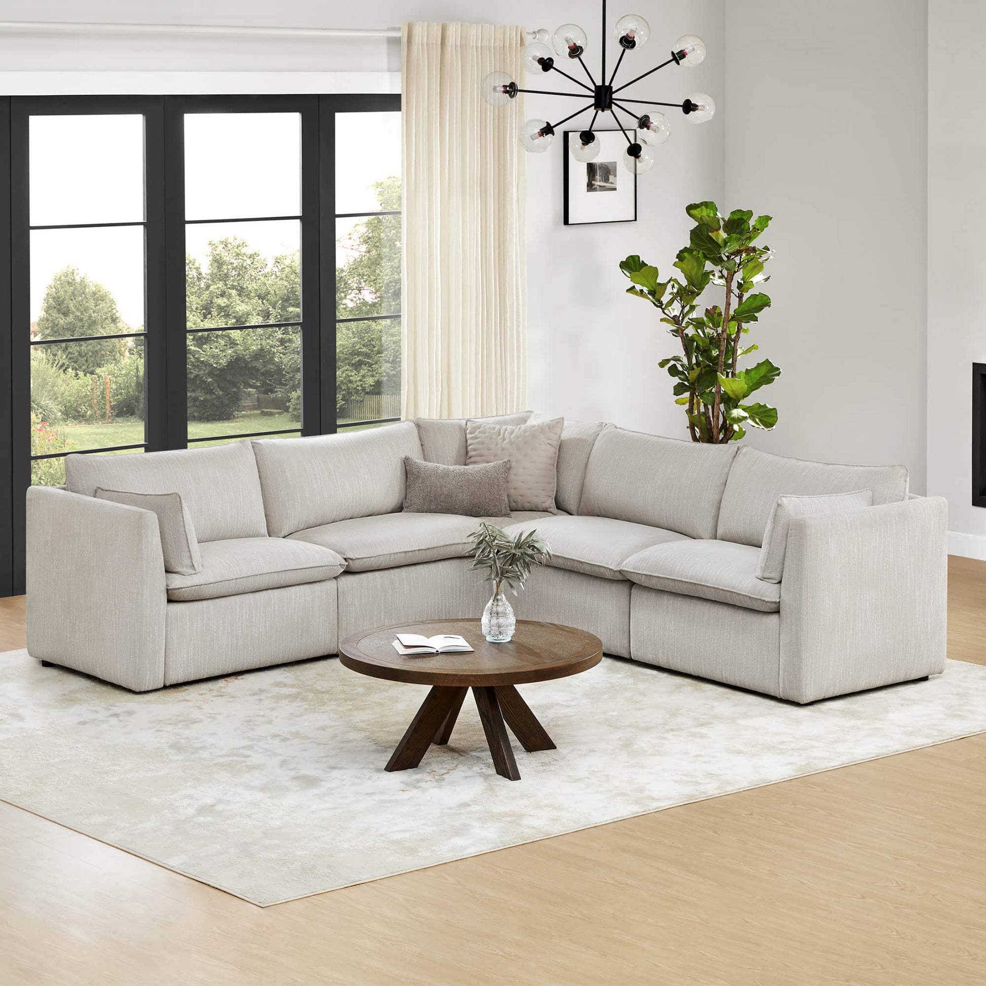 Sophia 5-piece modular sofa in a bright living room with large windows and round wooden coffee table - CHITA Living