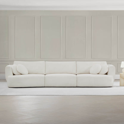 Grace modular curved sofa in light fabric with round cushions in sleek modern living space.