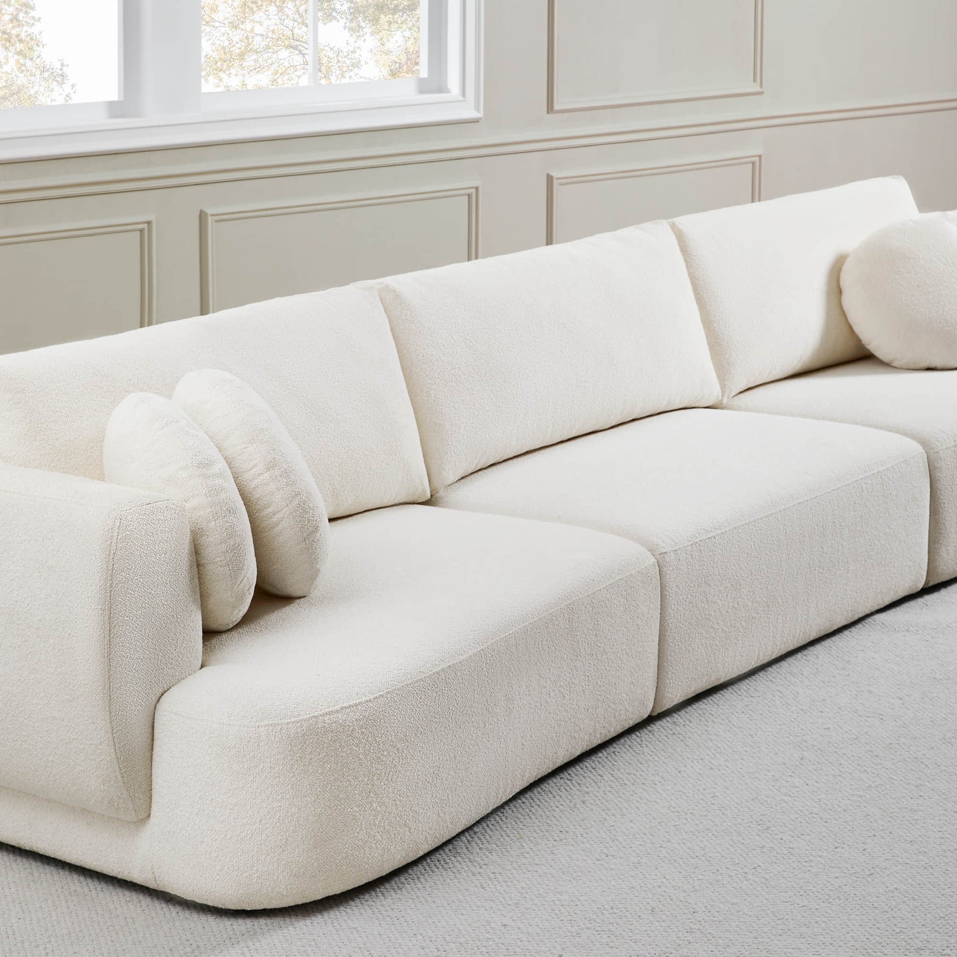 Grace 3-Seat Modular Curved Sofa in light boucle fabric with soft round cushions.