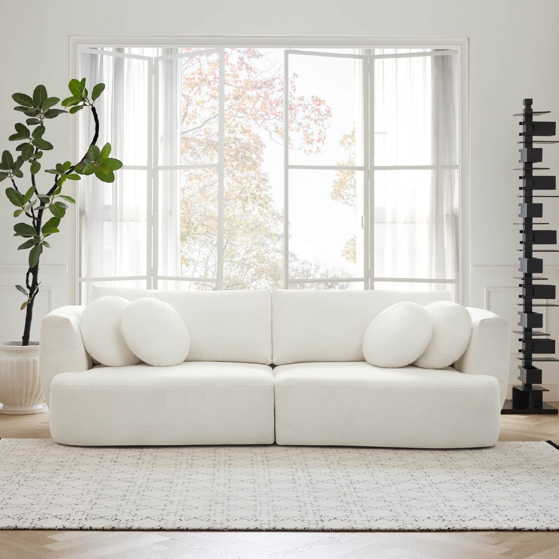 Grace modular curved white sofa with round cushions in a bright living room - CHITA Living