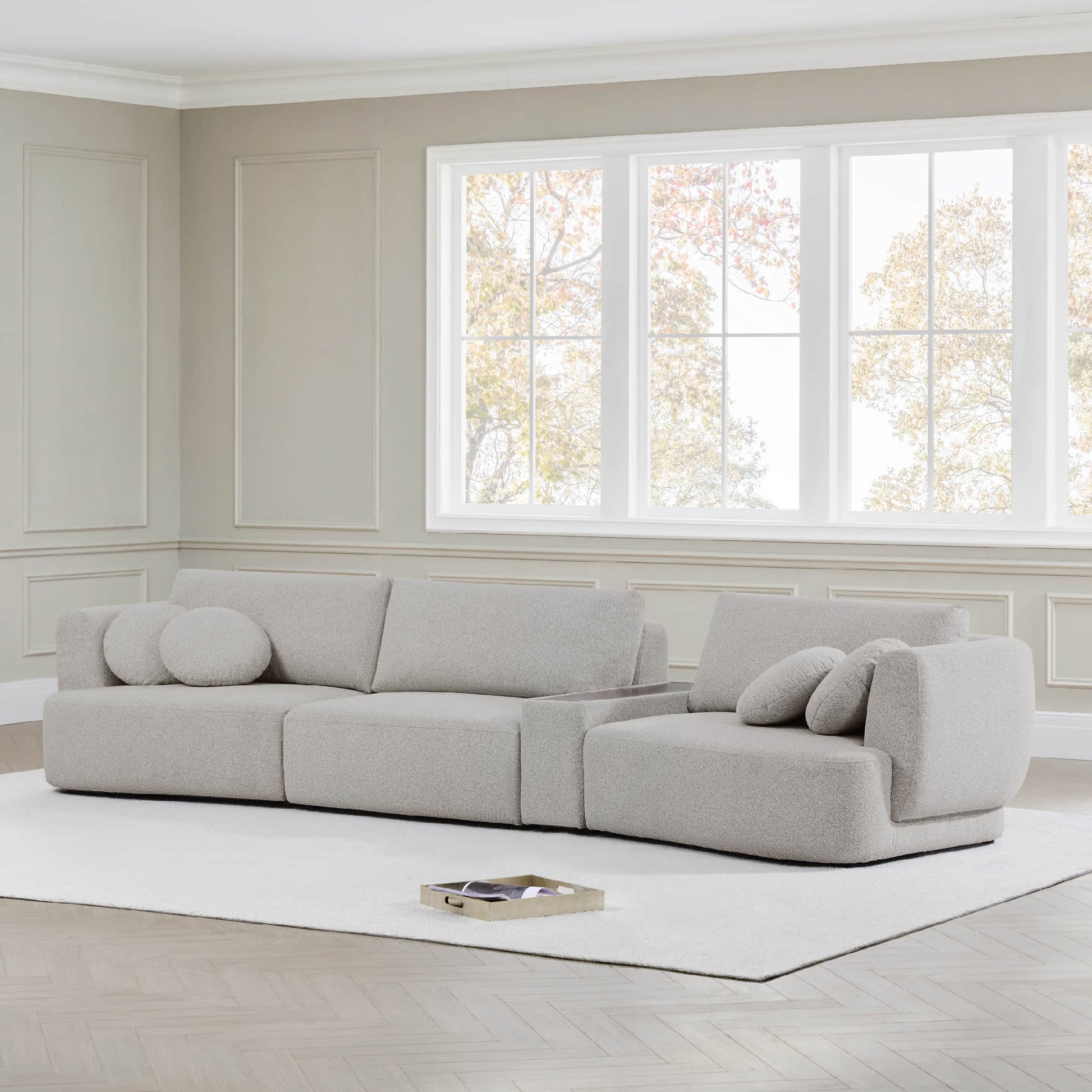 Grace 3-Seat Modular Curved Sofa in light boucle fabric with round cushions in bright room.