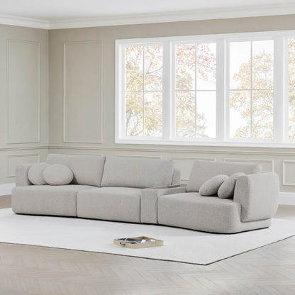 Grace 3-Seat Modular Curved Sofa in light boucle fabric with round cushions in bright room.