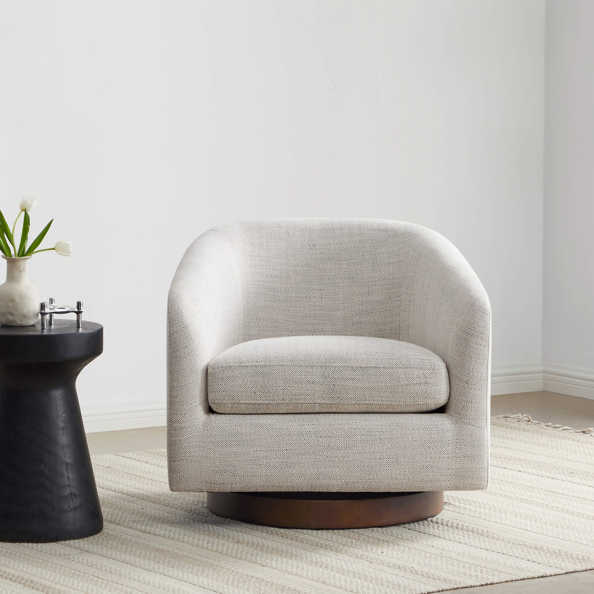 Beige Wren Modern Swivel Accent Chair with round base beside a dark side table - CHITA Living