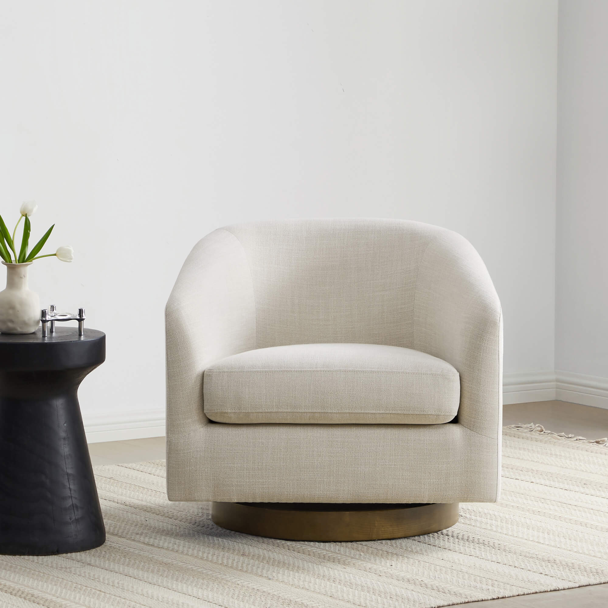 Beige swivel accent chair with round base beside a chic black side table - CHITA Living