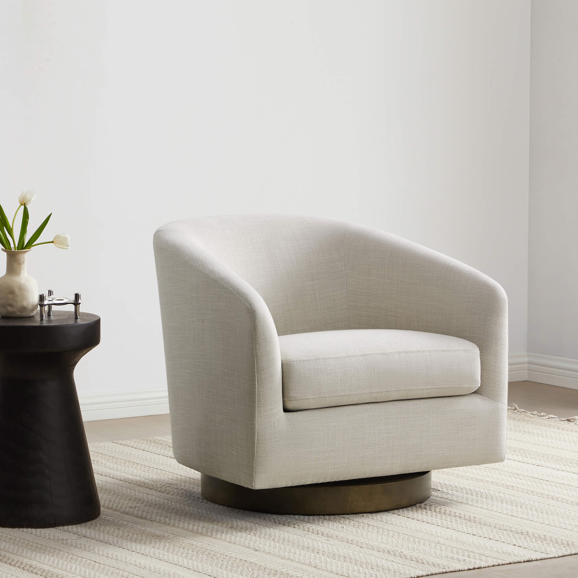 Light gray Wren Modern Swivel Accent Chair with round base beside a black side table - CHITA Living