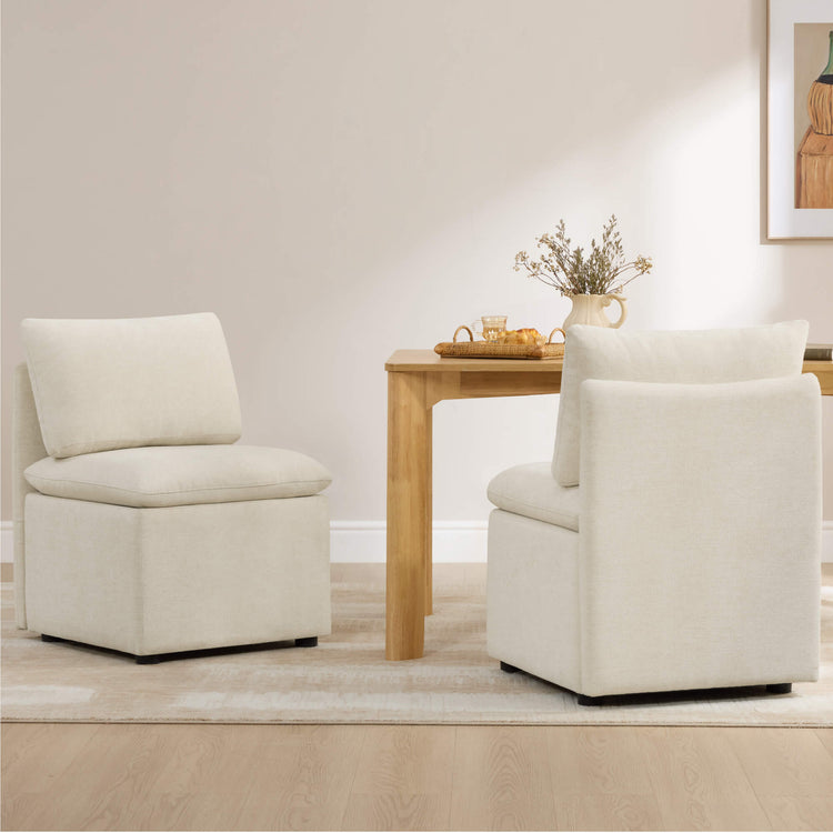 Two cream linen Lila minimalist armless dining chairs with plush cushions placed near a light wood dining table.