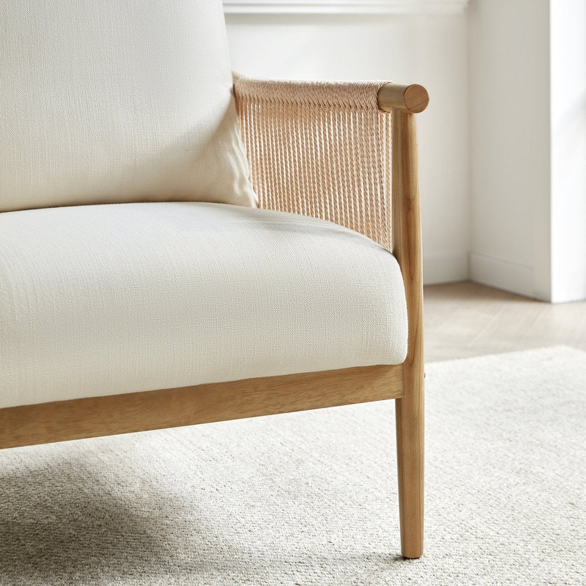 Sienna Modern Braid Chair with cream cushion and natural wood armrests in airy room - CHITA Living