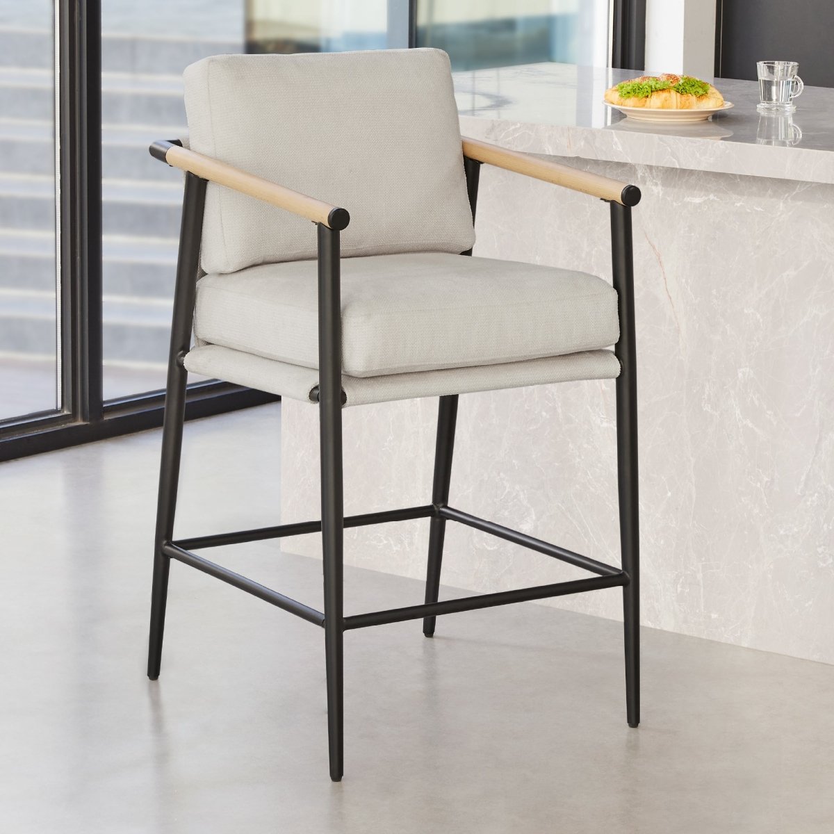 Charlotte Modern Counter Stool with light gray fabric and wooden armrests in a contemporary kitchen - CHITA Living