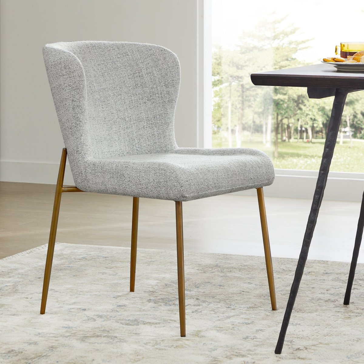 Golda Dining Chair in soft grey fabric with elegant brass legs in modern dining space - CHITA Living