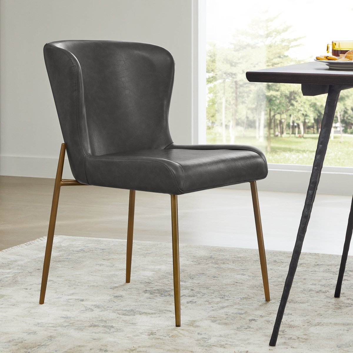 Golda Dining Chair in grey faux leather with elegant brass legs in modern dining area - CHITA Living