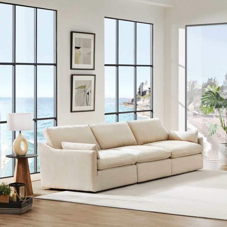 Kenna 3 Seat Modular Sofa in beige fabric in a living room with ocean view.